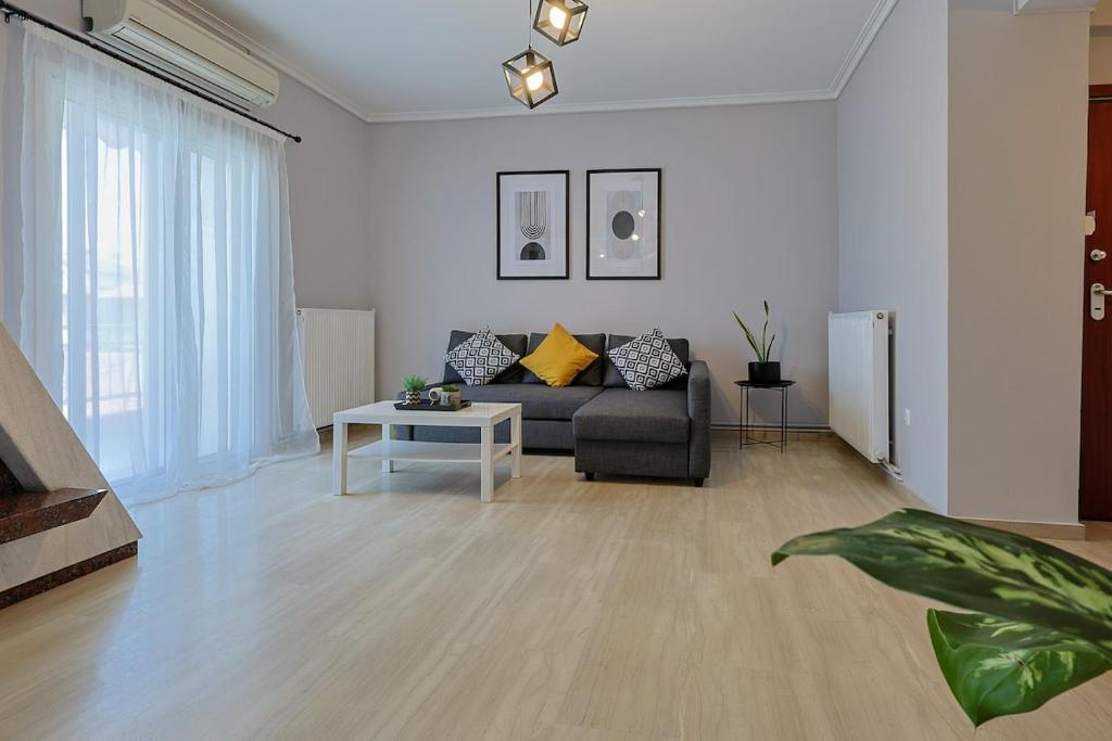 a living room with a couch and a table at John's Luxury Apartment in Paralia Katerinis