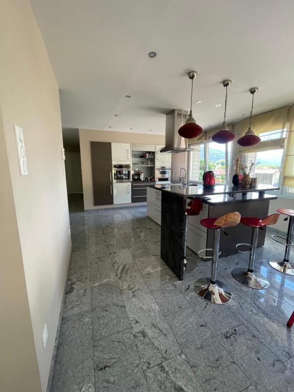 eine Küche mit einer Theke und Hockern in einem Zimmer in der Unterkunft Chambre superbe à découvrir au cœur des Vosges uni in La Celle-sous-Gouzon