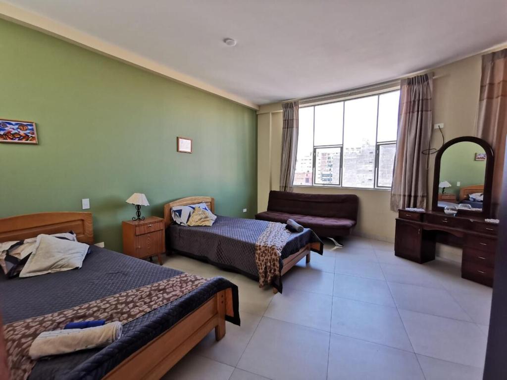 a hotel room with two beds and a mirror at Departamento amplio y céntrico in Cochabamba