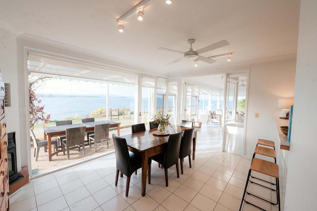 a dining room with a table and chairs and the ocean at Whalers Rest- Ocean Front- Victor Harbor in Encounter Bay