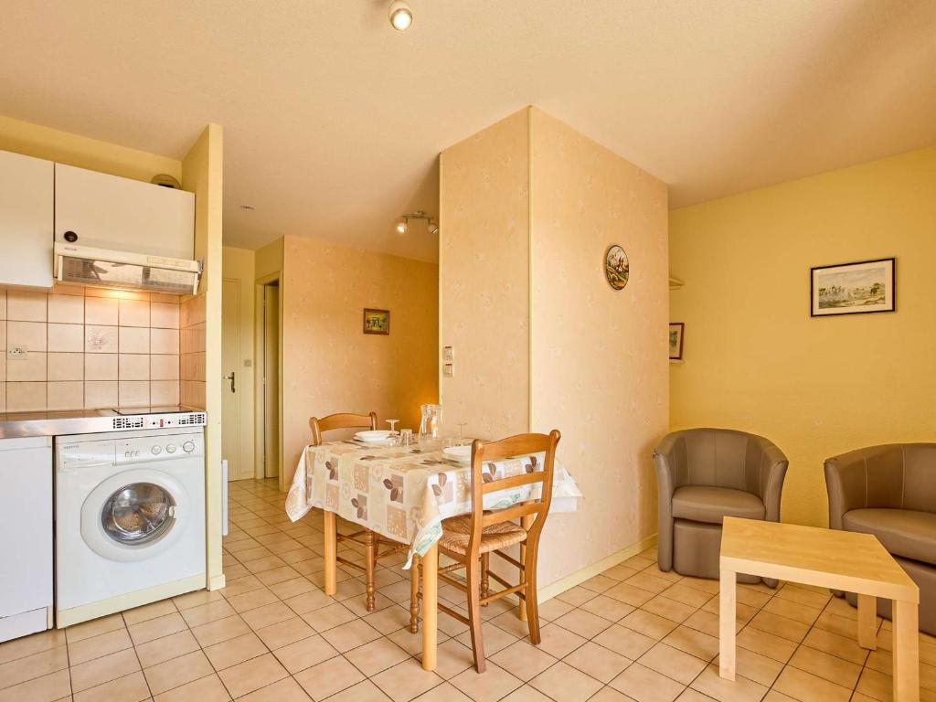 a kitchen and dining room with a table and a washing machine at T1 bis au calme avec balcon, proche des Thermes, WiFi Gratuit - FR-1-841-71 in Barbotan-les-Thermes