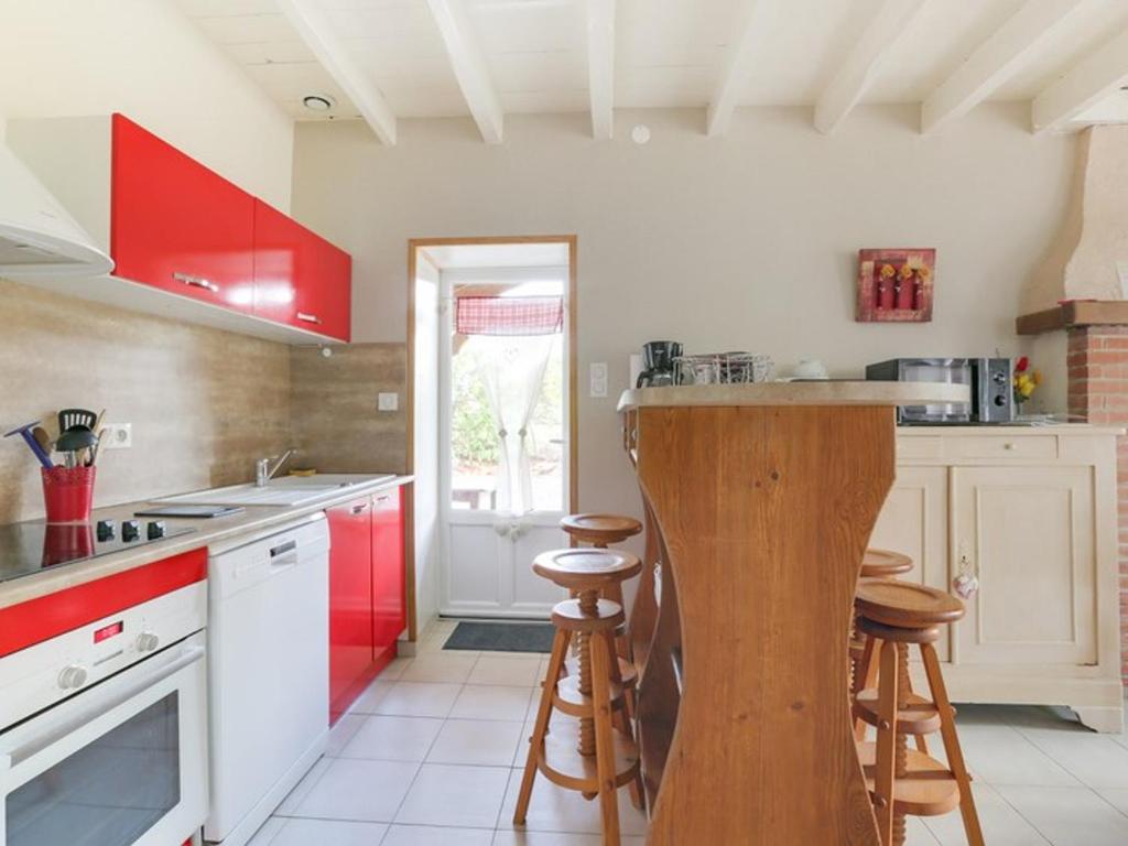 a kitchen with red and white cabinets and stools at Villa rénovée T3 près du lac et thermes - FR-1-841-60 in Cazaubon
