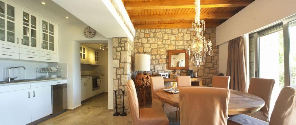a kitchen and dining room with a wooden table and chairs at Executive Rhodes Villa Villa Althea 2 Bedroom Villa With Sea Views Pefkos in Pefki Rhodes