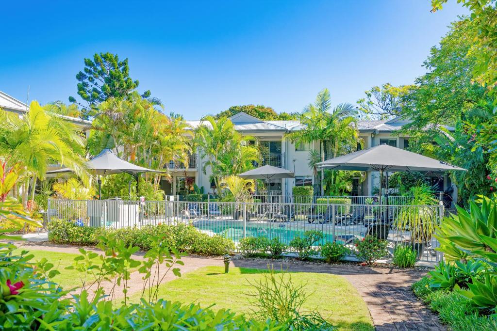 a house with a swimming pool and trees at Noosa River Retreat in Noosaville