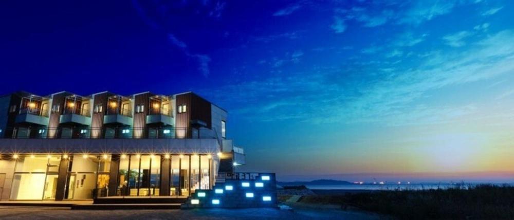Un edificio con luces en el frente por la noche. en Ongjin Pajama Blues, en Incheon