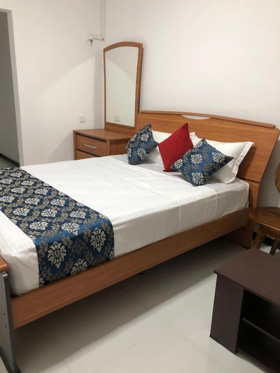 a bedroom with a bed with a mirror on it at Summer Villa in Badulla