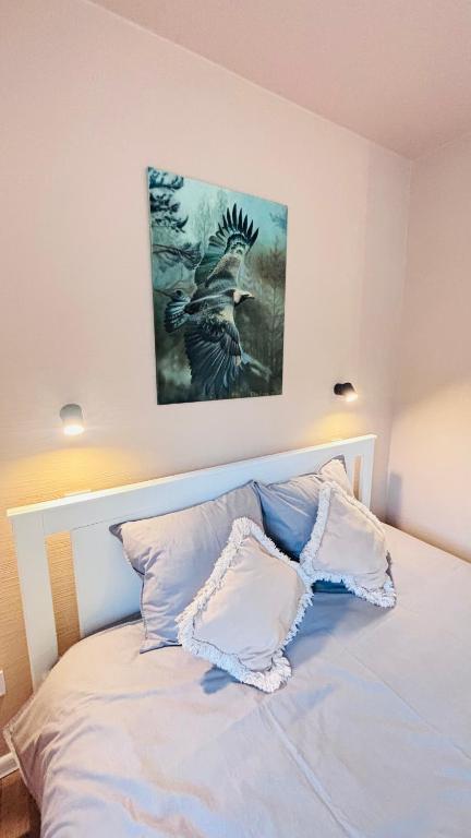 a bedroom with a bed with a painting on the wall at Valmiera Stay Apartment in Valmiera