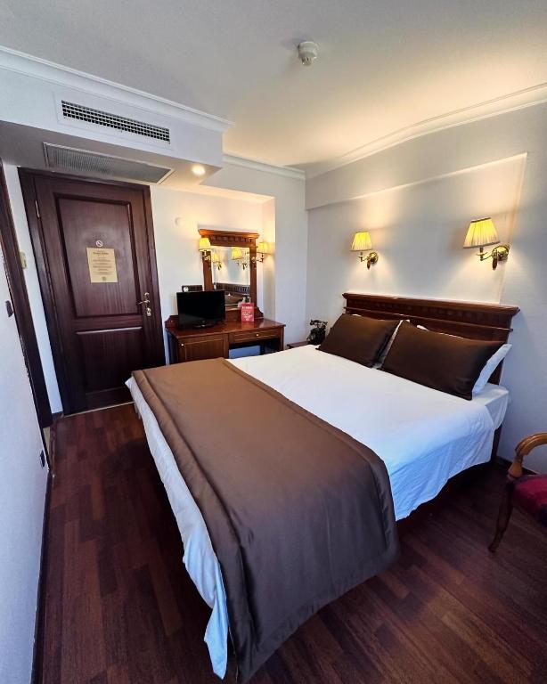 a hotel room with a large bed and a television at Emine Sultan Hotel in Istanbul
