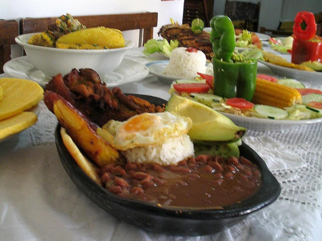 a table with a plate of food with meat and beans at Hotel Casa Vieja in Santa Marta