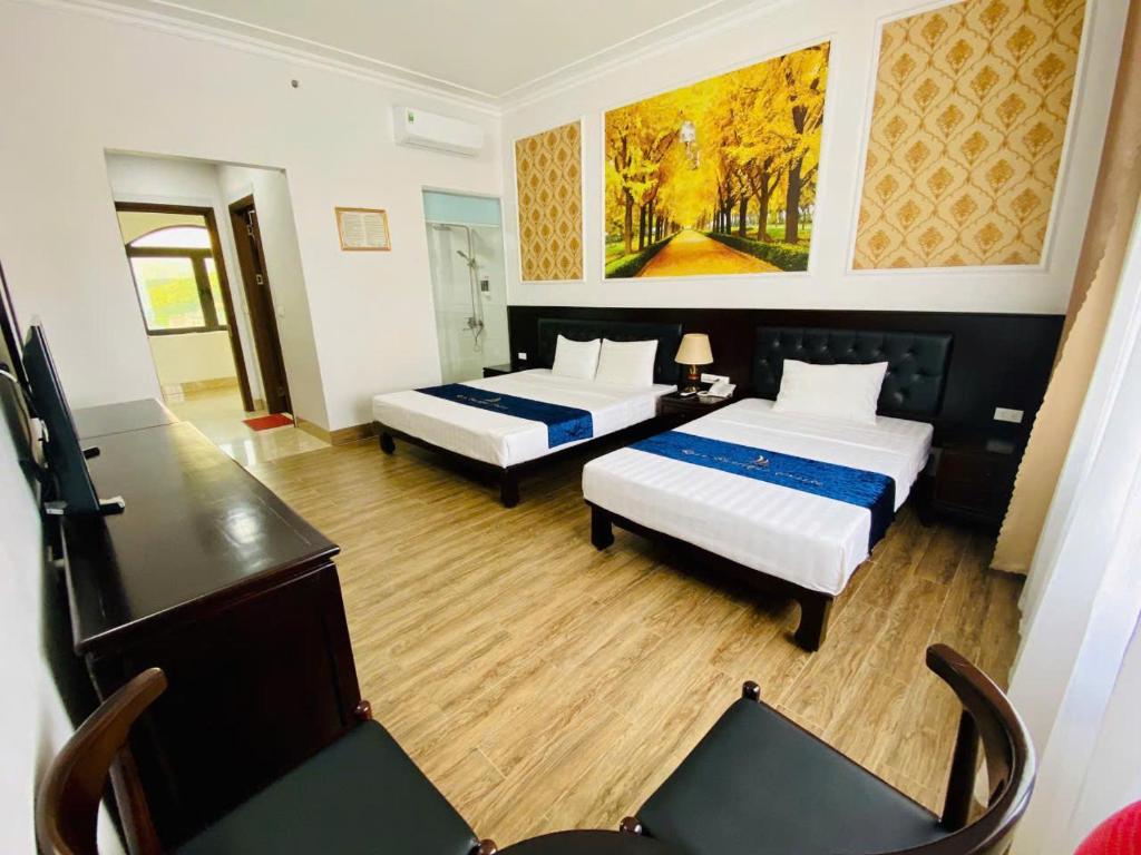 una habitación con dos camas y una mesa y sillas en Rosa Place - Hotel, en Xu Pau