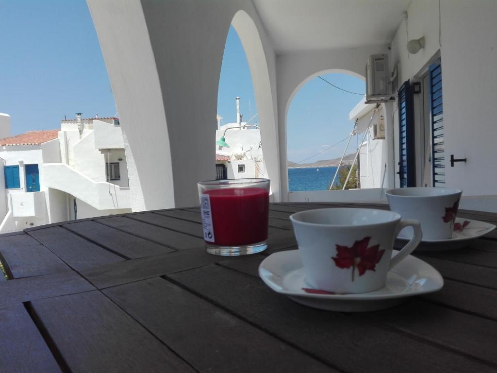 eine Tasse Kaffee auf einem Holztisch auf einem Balkon in der Unterkunft Tzamaros Studios in Mérikhas