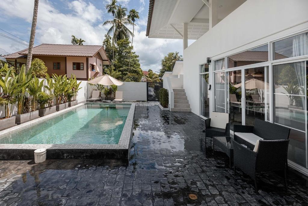 a swimming pool in the backyard of a house at Coconut Breeze Villa 3 in Haad Chao Phao