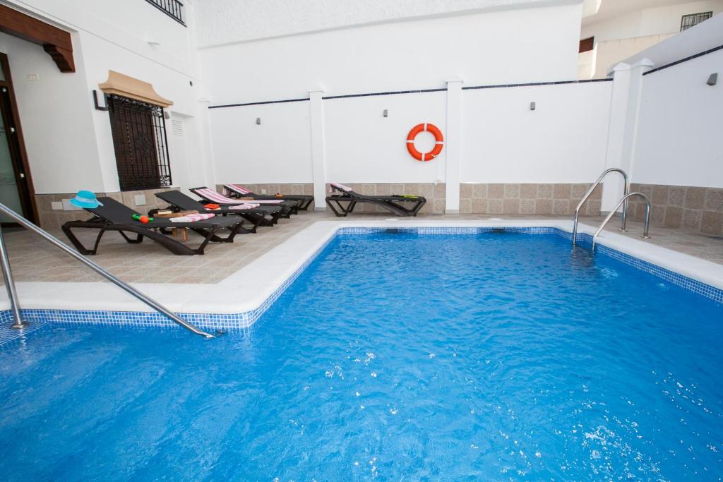 uma grande piscina com água azul num edifício em Hostal Boutique Bajamar em Nerja