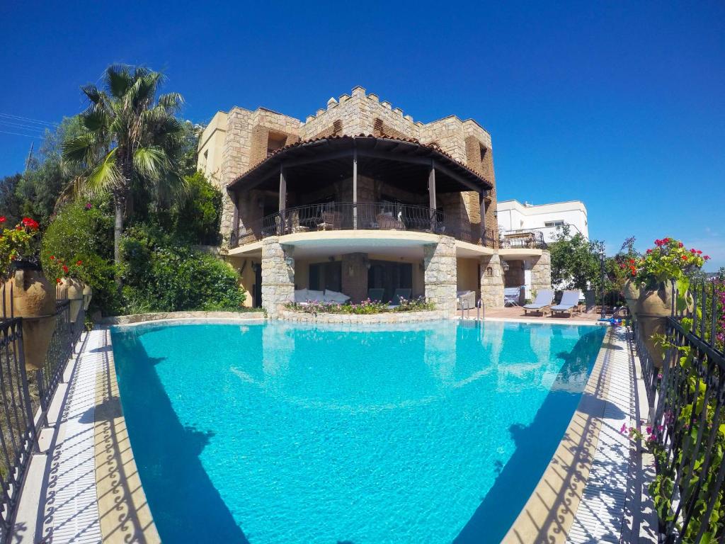 a large swimming pool in front of a house at Villa Cosy in Yalıkavak