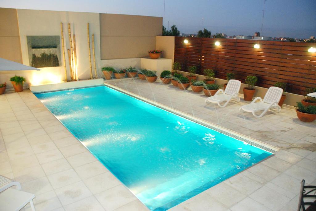 a swimming pool with two lawn chairs at Howard Johnson Villa María Hotel y Casino in Villa María