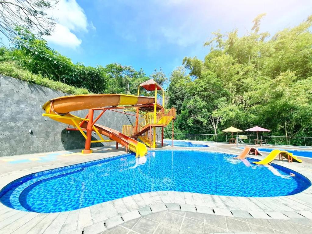 ein Schwimmbad mit Rutsche in einem Resortitamin in der Unterkunft Green Valley Resort Bandungan in Bandungan