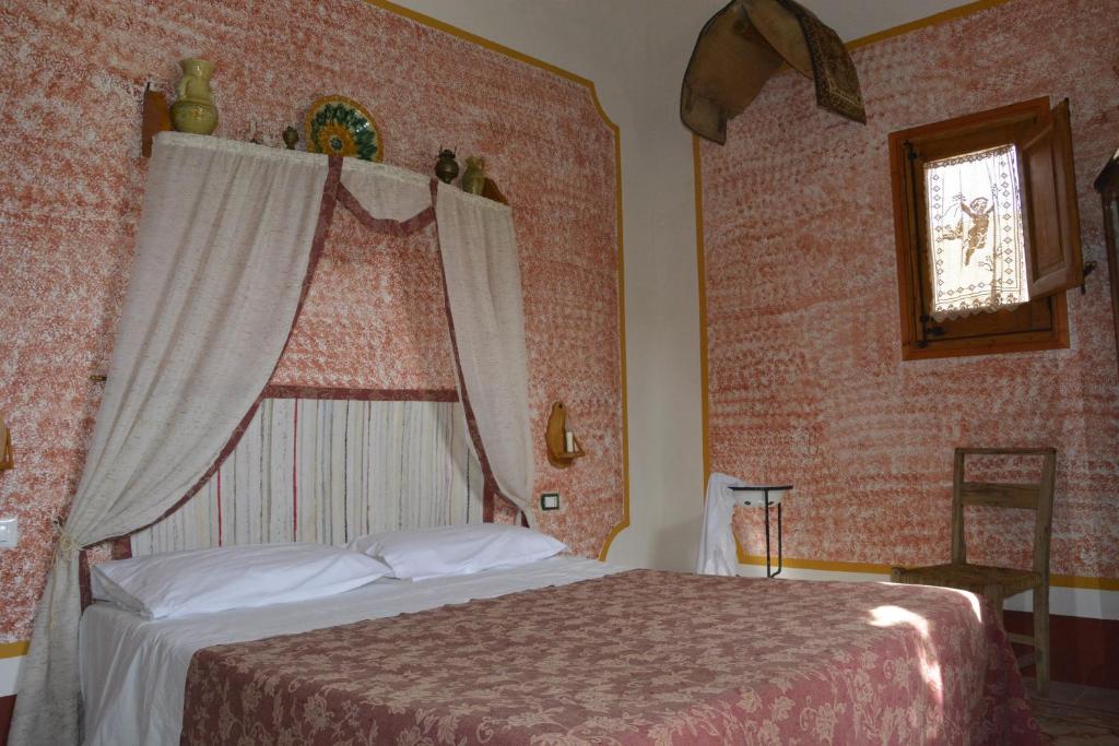 クストナーチにあるBaglio Trinacriaの窓付きの部屋にベッド付きのベッドルーム1室があります。