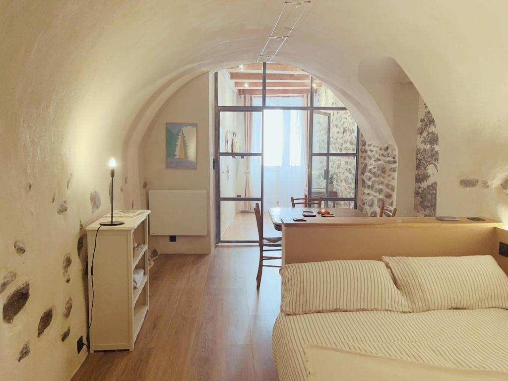 a room with a bed and a table and a kitchen at Charming Studio Saint Martin Vésubie in Saint-Martin-Vésubie