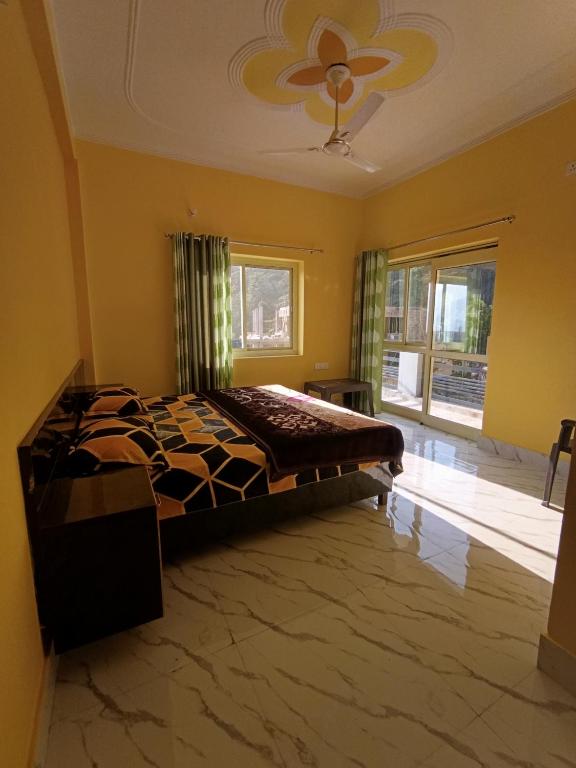 a bedroom with a bed and a large window at Welcome Home Stay & Hotel Tapovan Rishikesh in Rishīkesh