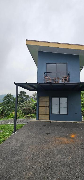 a blue house with a balcony on top of it at Rinconcito in Sabana Redonda