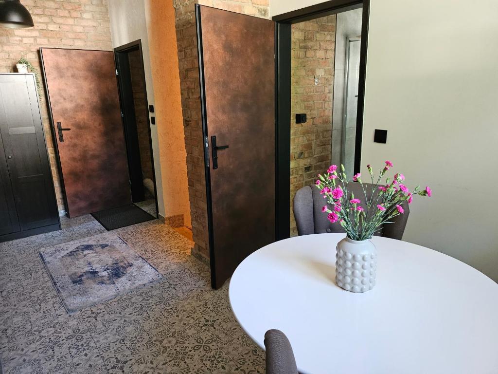 Una mesa blanca con un jarrón de flores. en Willa Konara, en Gdansk