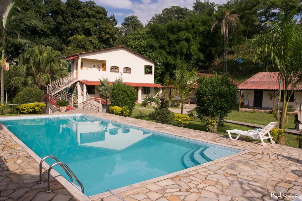 a swimming pool in front of a house at Pousada Chez Nous in Penedo