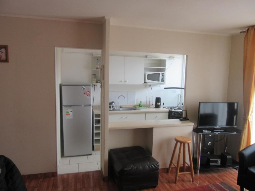 a small kitchen with a refrigerator and a counter at Cuatro Esquinas a pasos de Playa Serena in La Serena