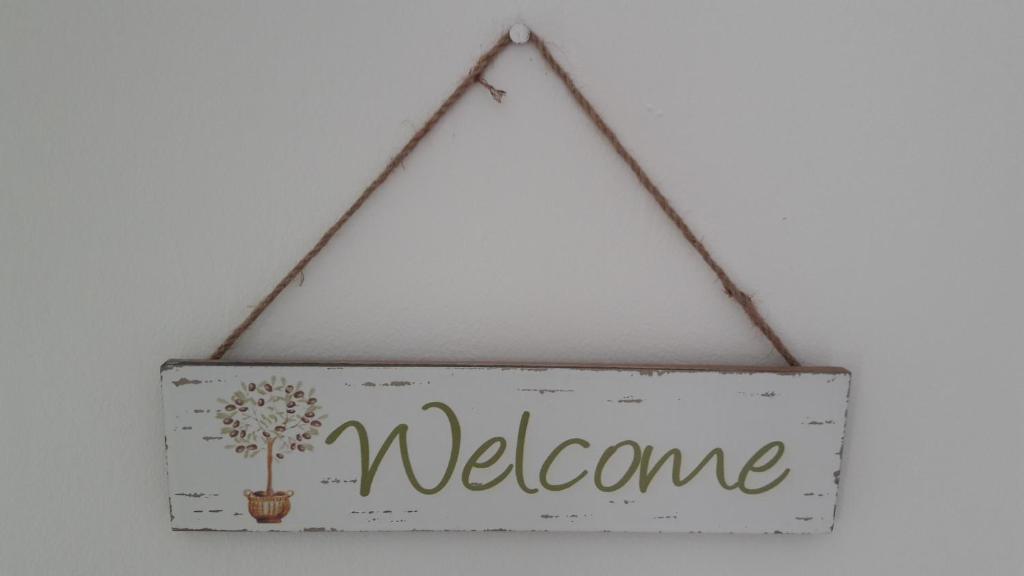a sign with the word welcome hanging on a wall at Pension Oaza in Hvar