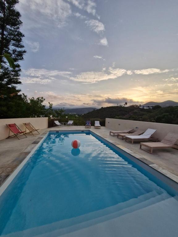 una piscina con una pelota en el agua en Vistamare Locations avec Piscine saint florent, en Saint-Florent