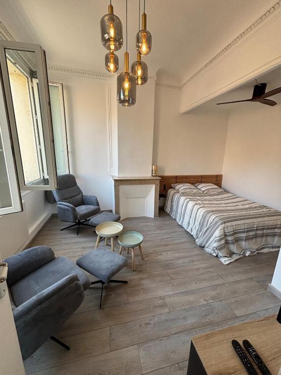 une chambre avec un lit, un canapé et des chaises dans l'établissement L'Atelier D'AIX, à Aix-en-Provence
