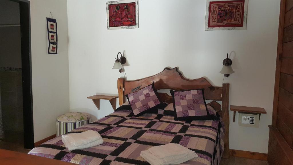 1 dormitorio con 1 cama con manta a cuadros en Cabañas de Colores en Los Reartes