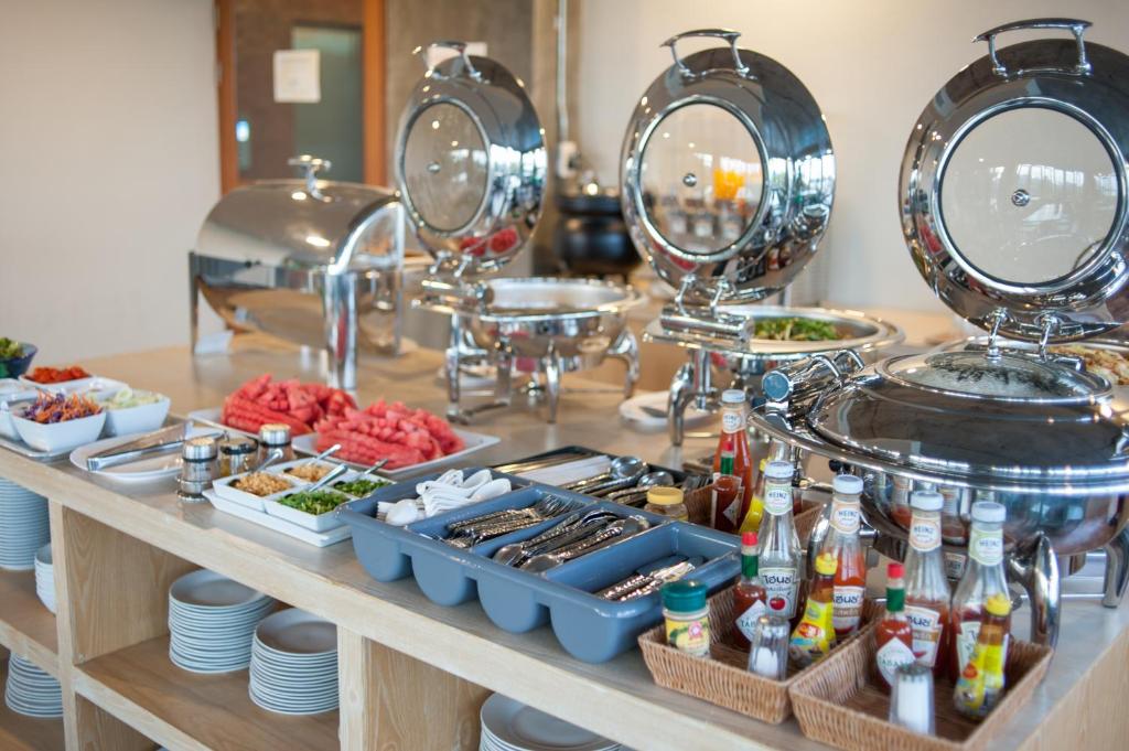 a buffet with food and dishes on a table at The Sixteenth Naiyang Beach Hotel SHA Plus in Nai Yang Beach