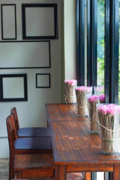 a wooden table with pink flowers in baskets on it at The Sixteenth Naiyang Beach Hotel SHA Plus in Nai Yang Beach