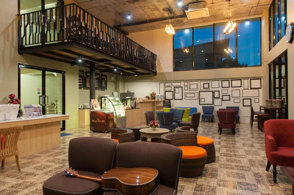a lobby with couches and tables and chairs at The Sixteenth Naiyang Beach Hotel SHA Plus in Nai Yang Beach