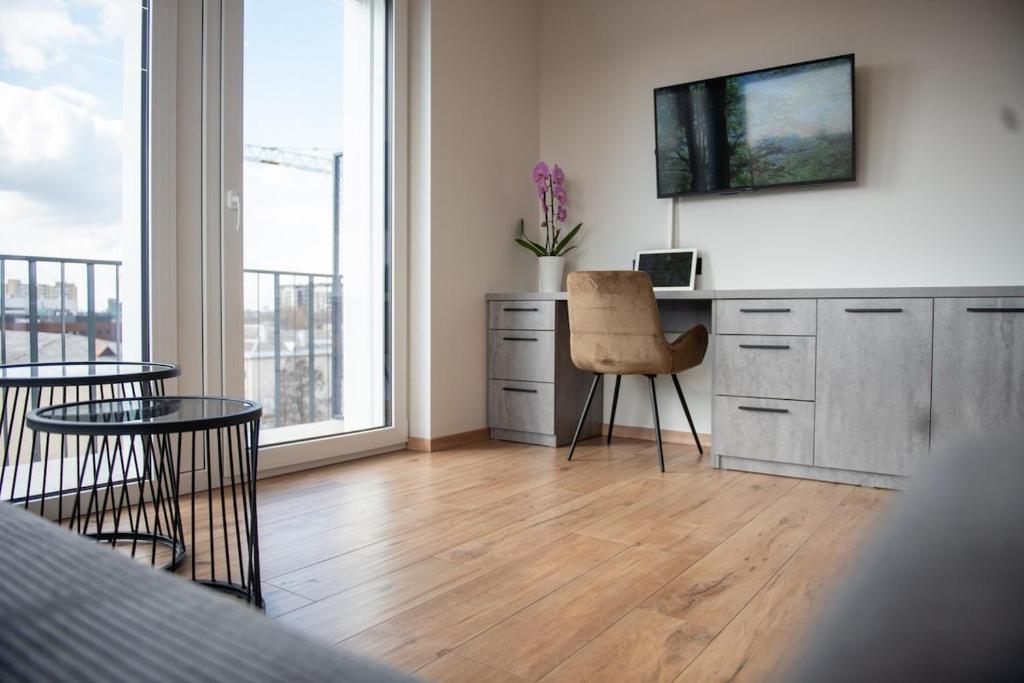 - une cuisine avec un bureau, un ordinateur portable et une chaise dans l'établissement Sunlit City Loft- Prime Views, à Vilnius