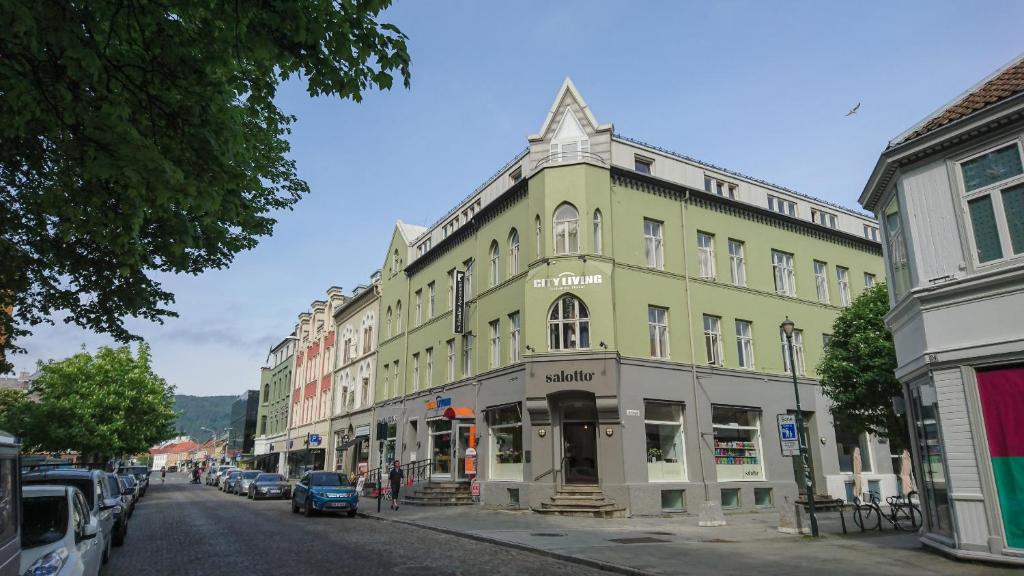 a green building on the side of a street at City Living Schøller Hotel in Trondheim