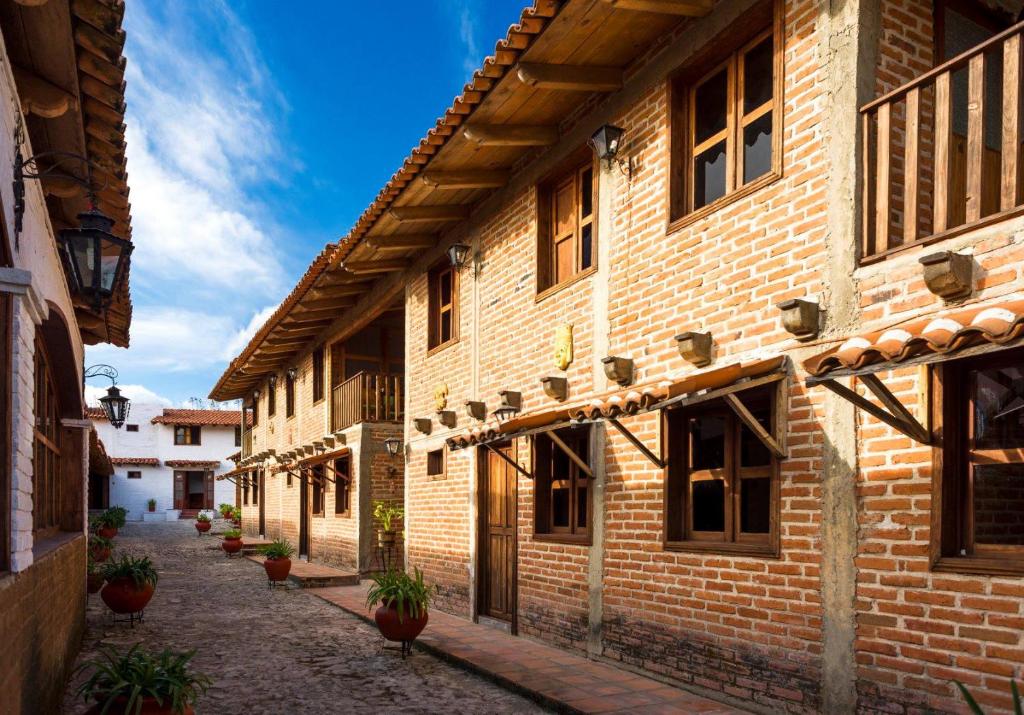 塔巴巴的住宿－Hotel de Campiña，一座种植了盆栽植物的古老建筑中的小巷