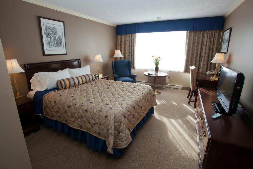 Postel nebo postele na pokoji v ubytování The Fredericton Inn