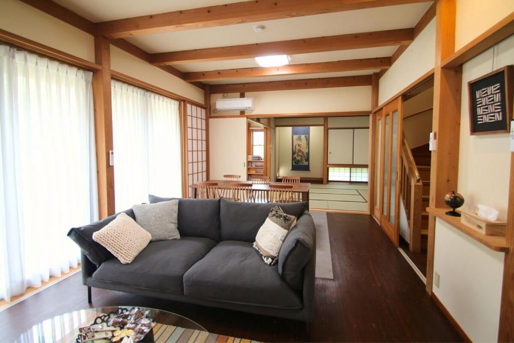 a living room with a couch and a table at Shinyashiki Guest House in Kumamoto