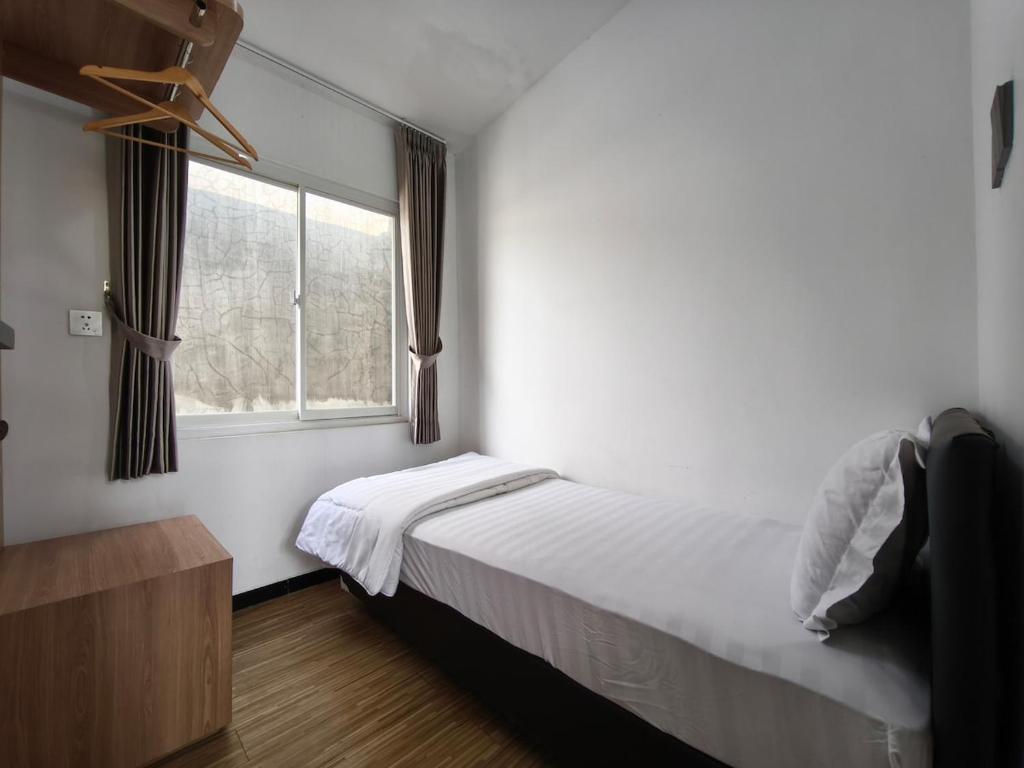 a small bedroom with a bed and a window at Villa Royal Arois Unit C-01 in Batu