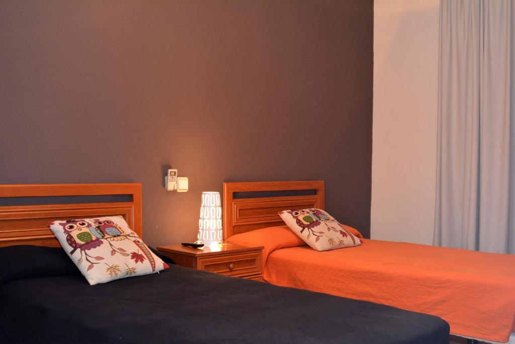 two beds sitting next to each other in a bedroom at Hostal Gastrobar Carmelo in Villarejo de Salvanés
