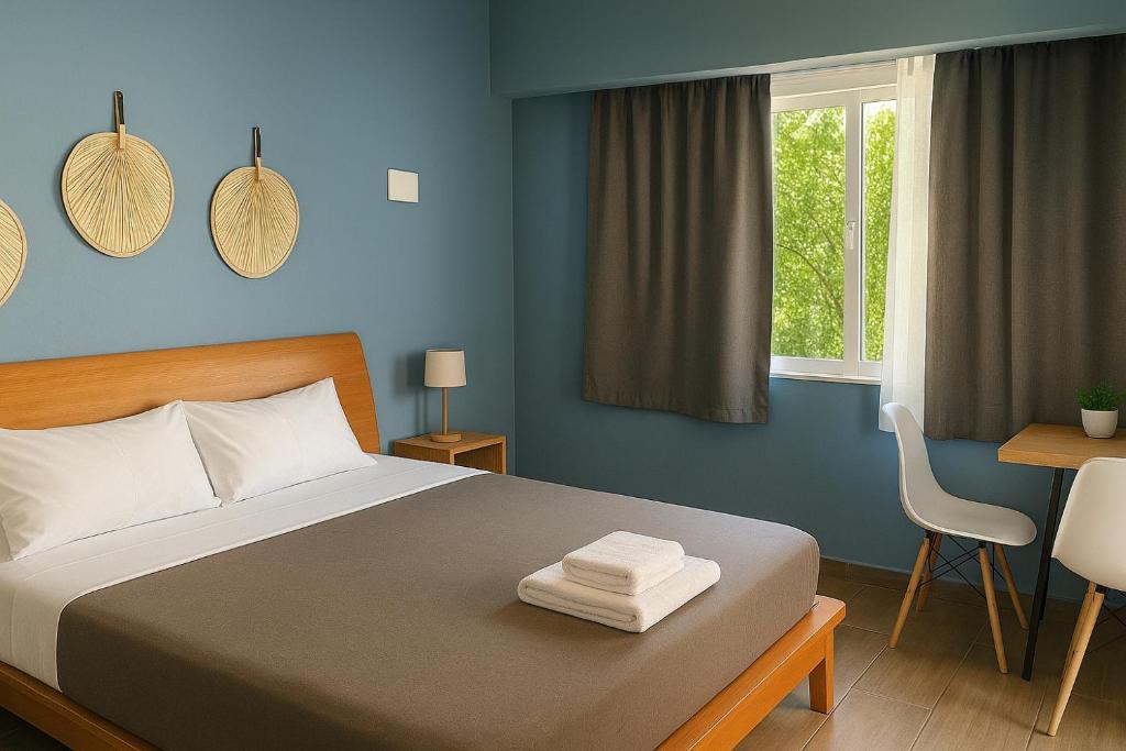 una camera da letto con un letto, una scrivania e una finestra di Blue studio a Néa Michanióna