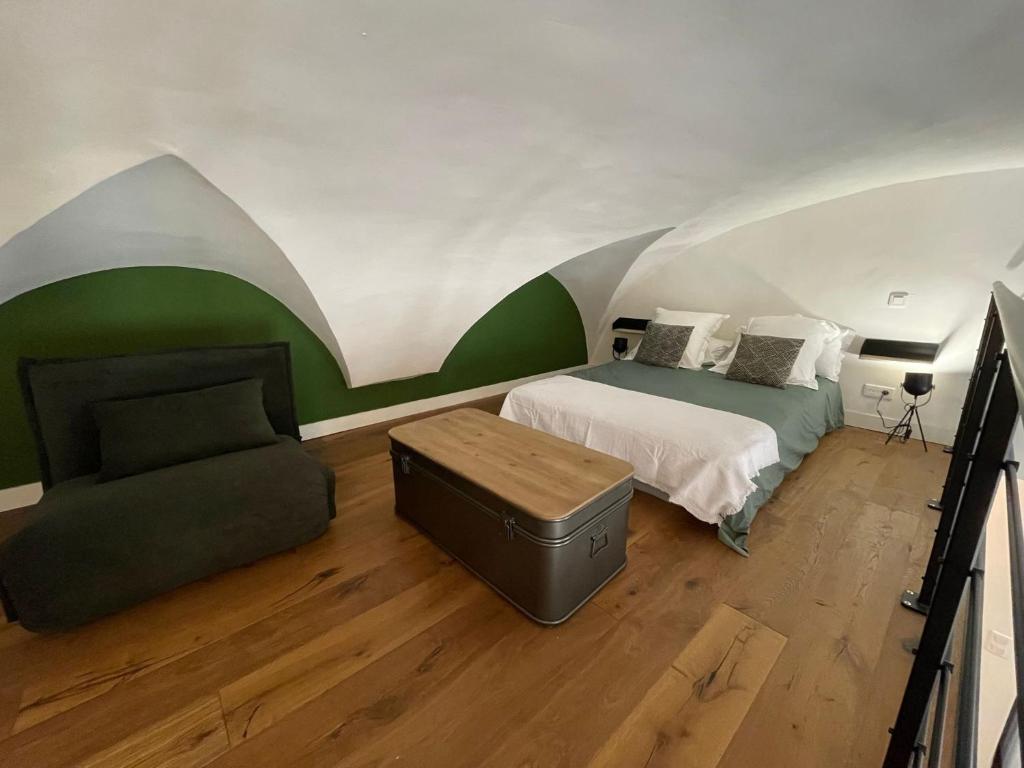 a bedroom with a bed and a chair in it at Nid douillet - maison Spinola in Bastia