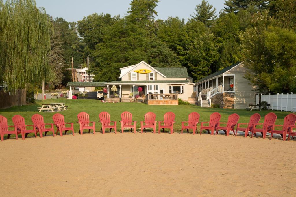 un grupo de sillas rojas sentadas frente a una casa en Shore Meadows Lodge LLC, en Lake George