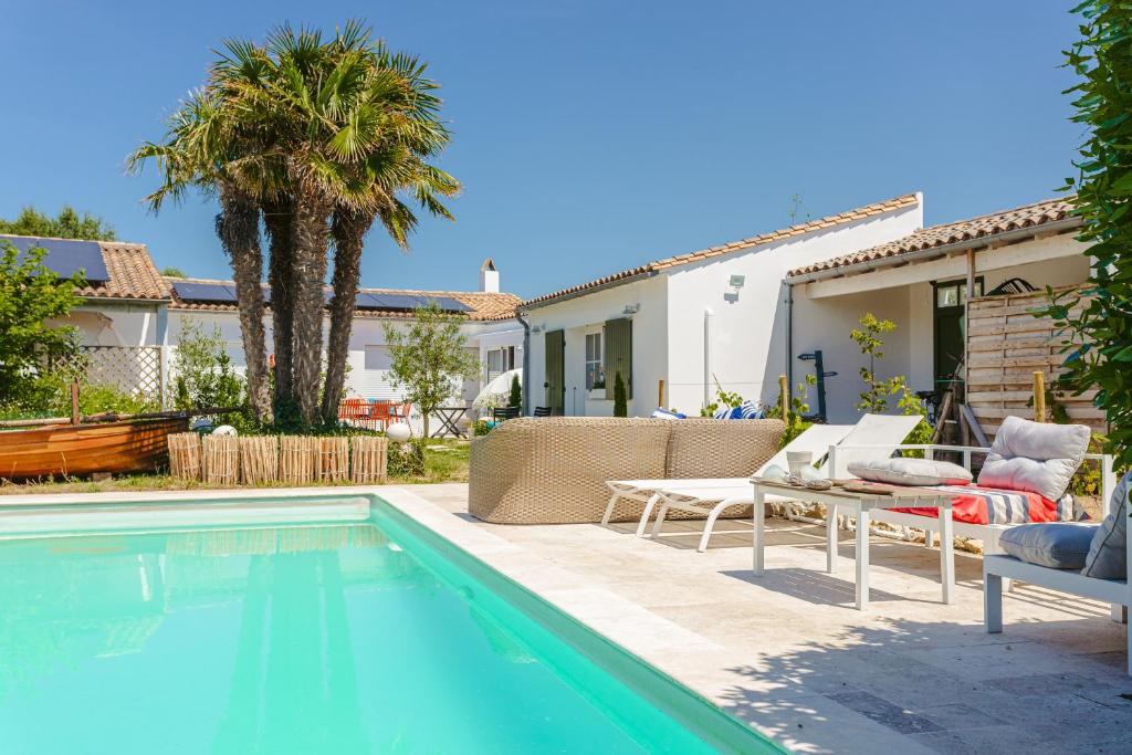 een achtertuin met een zwembad en een huis bij Escapades Océanes in Sainte-Marie-de-Ré