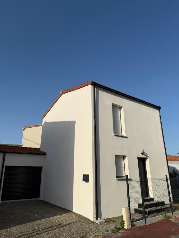 a white building with a garage at Maison de la Pornicaise 13 in Saint-Jean-de-Monts