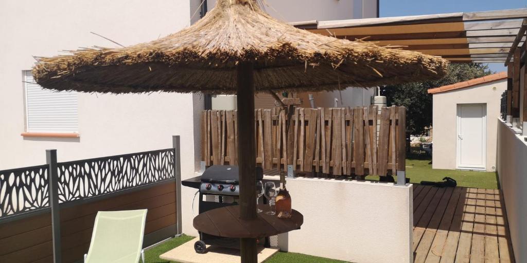 un parasol de terrasse avec un gril dans une cour dans l'établissement Gîte du Couchant, à Sorède