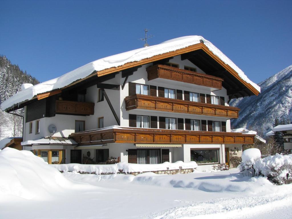 ein großes Gebäude mit Schnee darüber in der Unterkunft Anna's Appartements in Pertisau