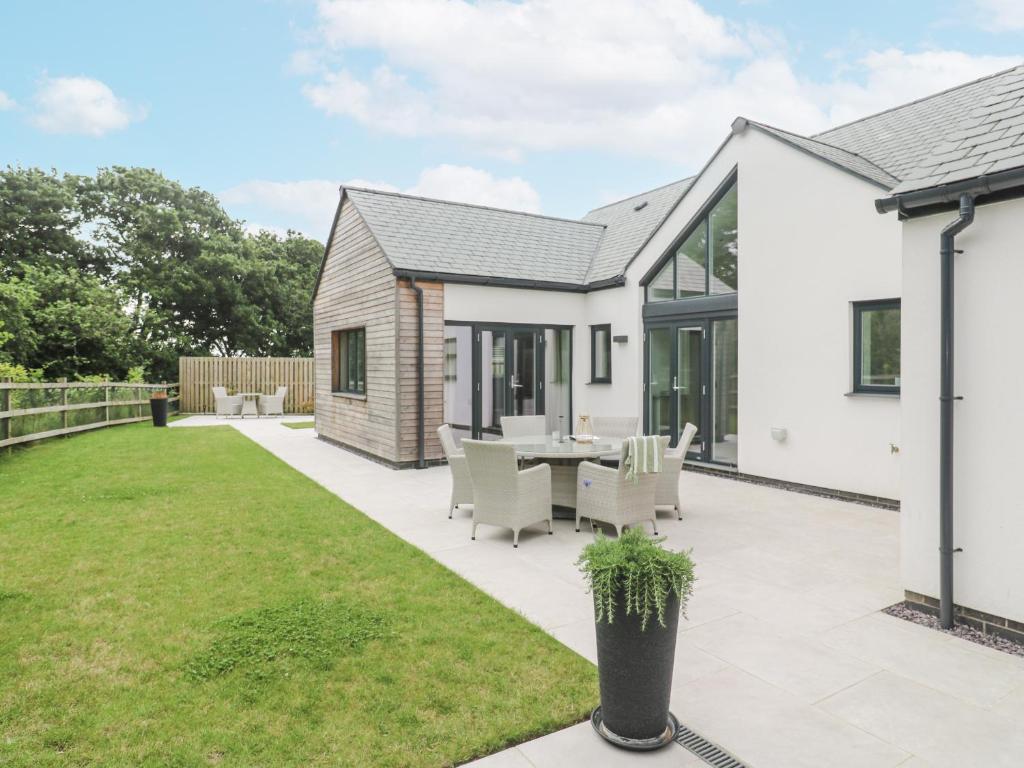 an extension to a house with a patio and grass at Kerrek Lodge in Falmouth