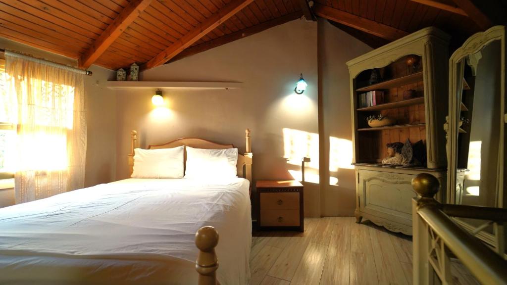 a bedroom with a white bed and a book shelf at ART HOUSE in Parga